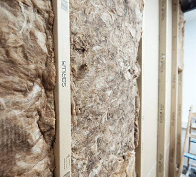 Trockenbauwand mit Dämmung und vertikal angeordneten SORIWA Zellfaserstoffprofilen, die Multi Profile, während der Ausbauphase eines Innenausbauprojekts.